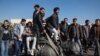 Students stand on the toppled statue of late president Hafez al-Assad during a rally near the campus of the Damascus University in the Syrian capital on December 15, 2024.