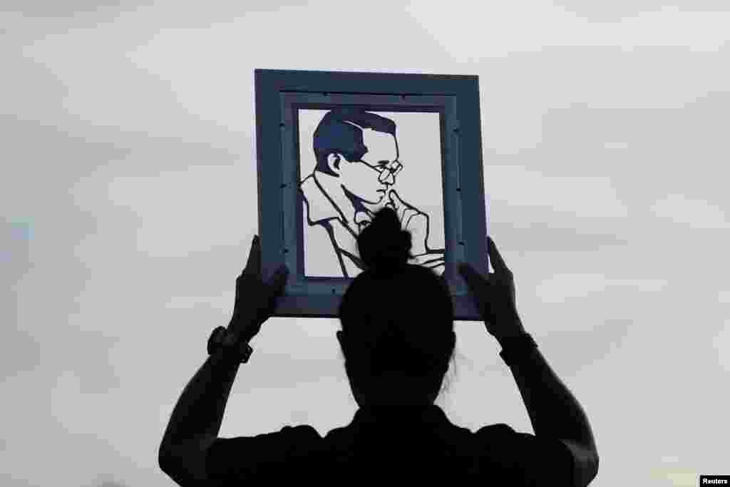 A woman holds the portrait of Thailand's late King Bhumibol Adulyadej near the Grand Palace in Bangkok, Thailand, October 25, 2017.