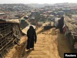 FILE - A woman walks up a hill in the Kutupalong camp for Rohingya refugees in southern Bangladesh, Feb. 11, 2018.