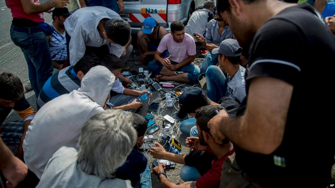 ARHIVA - Migranti pune mobilne telefone u blizini Horgoša