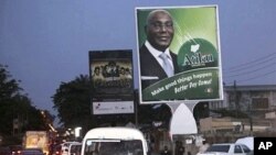 Cars pass a billboard, right, with a photo of Nigerian Political candidate Alhaji Atiku Abubakar who will stand against Nigerian President Goodluck Jonathan for the ruling party nomination at Lagos, Nigeria, 22 Nov. 2010.