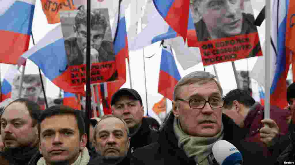 Opposition leader and Russia's former Prime Minister Mikhail Kasyanov, right, speaks to the media with opposition activist Ilya Yashin, left, during a march to commemorate Kremlin critic Boris Nemtsov, who was shot dead Friday, in Moscow, March 1, 2015.