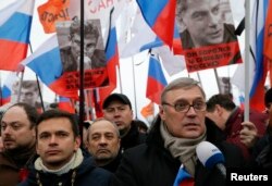FILE - Opposition leader and Russia's former Prime Minister Mikhail Kasyanov, right, speaks to the media with opposition activist Ilya Yashin, left, during a march to commemorate Kremlin critic Boris Nemtsov, who was shot dead, in Moscow, March 1, 2015.