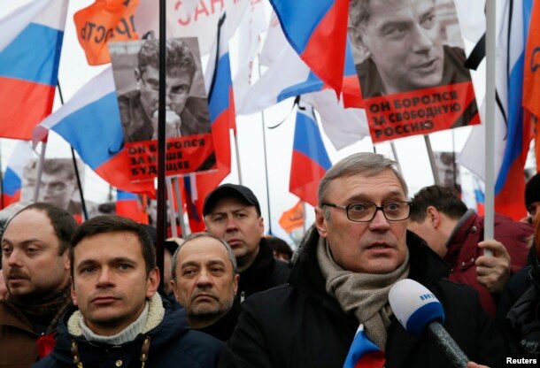 FILE - Opposition leader and Russia's former Prime Minister Mikhail Kasyanov, right, speaks to the media with opposition activist Ilya Yashin, left, during a march to commemorate Kremlin critic Boris Nemtsov, who was shot dead, in Moscow, March 1, 2015.