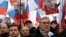 Opposition leader and Russia's former Prime Minister Mikhail Kasyanov, right, speaks to the media with opposition activist Ilya Yashin, left, during a march to commemorate Kremlin critic Boris Nemtsov, who was shot dead Friday, in Moscow, March 1, 2015. 