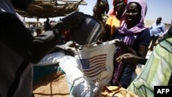 Des sud-soudanais collectent de la nourriture dans un centre pour réfugiés à Al-Eligat, près de la frontière avec le Soudan, le 27 février 2017.