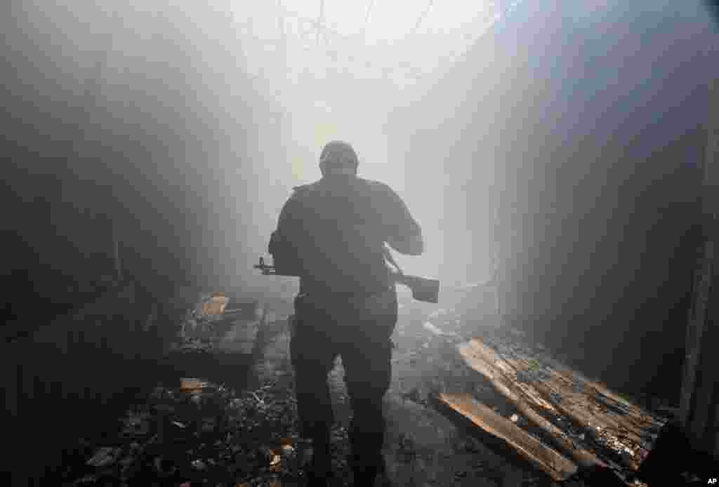 A pro-Russian rebel walks in a passage at the local market damaged by shelling in the Petrovskiy district, town of Donetsk, eastern Ukraine, Aug. 26, 2014.