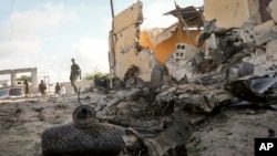 FILE - A Somali soldier observes the scene of a car bomb attack in Mogadishu, June 21, 2015. The al-Qaida-linked al-Shabab extremist group tried to attack an intelligence training compound, a police officer said. President Donald Trump has now given the U.S. military more authority to conduct offensive airstrikes on al-Qaida-linked militants.