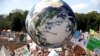 Balon bergambar bola dunia diterbangkan di tengah kerumunan massa, banyak dari mereka siswa sekolah, yang berkumpul di Sydney, Jumat, 20 September 2019, menyerukan tindakan untuk menjaga dunia terhadap perubahan iklim. (AP/Rick Rycroft)