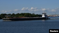 A barge travels through the Houston Ship Channel, part of the Port of Houston, in Pasadena, Texas, May 5, 2019. 