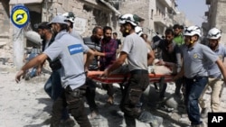 FILE - Rescue workers are seen on the site of airstrikes in a neighborhood of the rebel-held part of eastern Aleppo, Syria, in a Sept. 21, 2016, photo provided by the Syrian Civil Defense group 'White Helmets.'