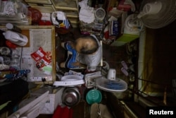 FILE - Kwok Kwai, 65, poses for a photo inside his subdivided flat in Hong Kong, Aug. 8, 2024.