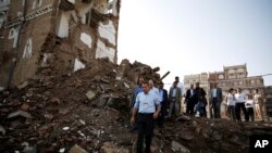 FILE - Peter Maurer, the president of the International Committee of the Red Cross, center, walks near houses destroyed by a Saudi-led airstrike during his visit to the old city of Sanaa, Yemen, Sunday, Aug. 9, 2015.
