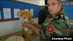 A Kurdish fighter holds a stuffed teddy bear, used to conceal a weapon. It's just one item gathered from battles against Islamic State militants and to be displayed as part of a museum in Duhok, Iraq. (VOA/Kawa Omar)