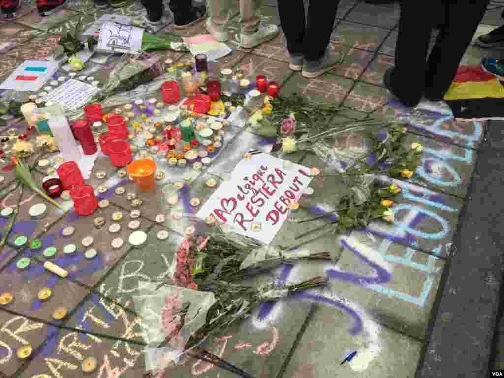 Sign at makeshift memorial for terror bombing victims reads in French: "Belgium will remain standing", Brussels, Belgium, March 23, 2016. (N. Pourebrahim / VOA)