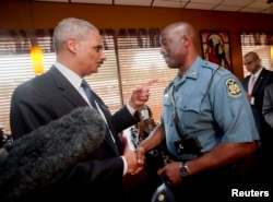 Attorney General Eric Holder talks with Capt. Ron Johnson of the Missouri State Highway Patrol at Drake's Place Restaurant in Ferguson, Missouri, August 20, 2014.