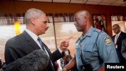 aksa Agung AS Eric Holder berbicara dengan Kapten Ron Johnson dari Patroli Jalan Layang Missouri di Restauran Drake's Place di Ferguson, Missouri (20/8). (Reuters/Pablo Martinez Monsivais)