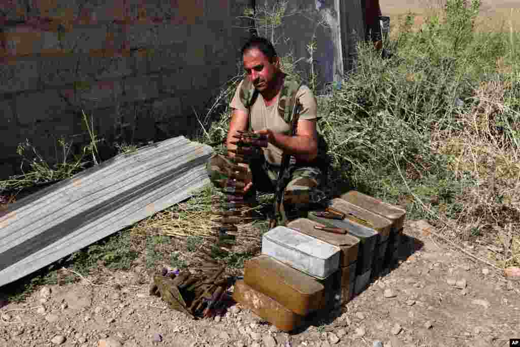 A Kurdish peshmerga fighter prepares his ammunition near the Mosul Dam, outside Mosul, Iraq, Aug. 17, 2014.
