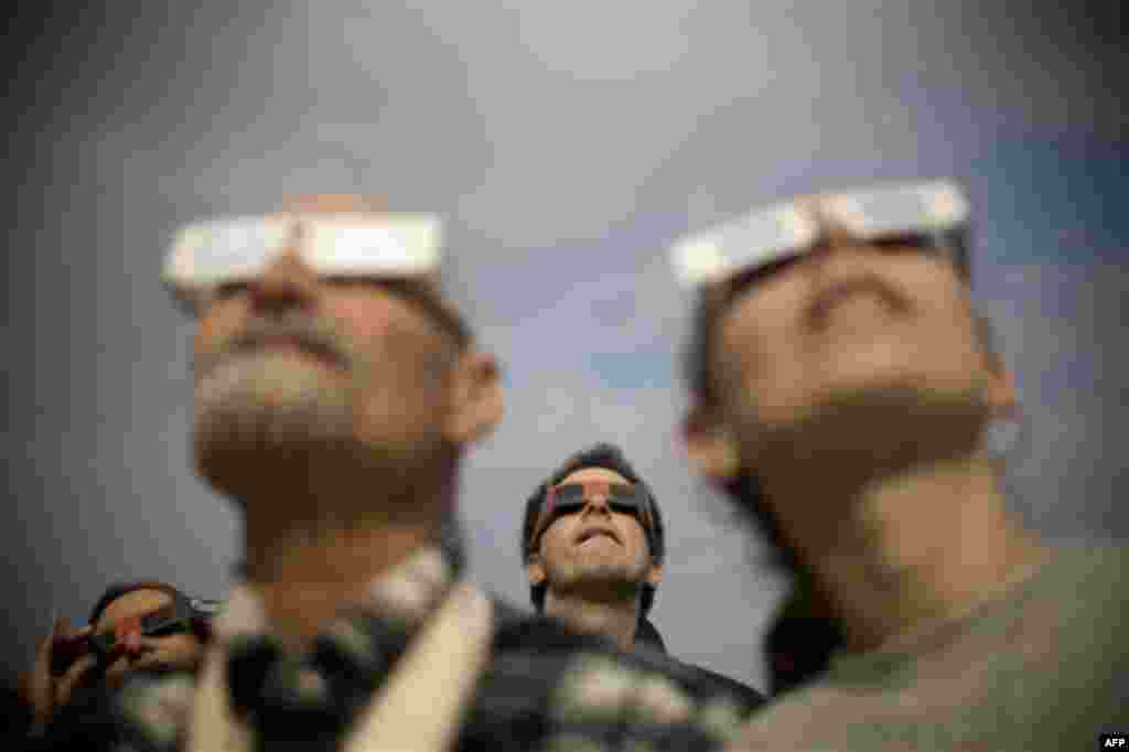 Jan 4: Israelis watch a partial solar eclipse in the town of Givatayim near Tel Aviv, Israel. A partial solar eclipse began Tuesday in the skies over the Mideast and will extend across much of Europe (Ariel Schalit/AP)
