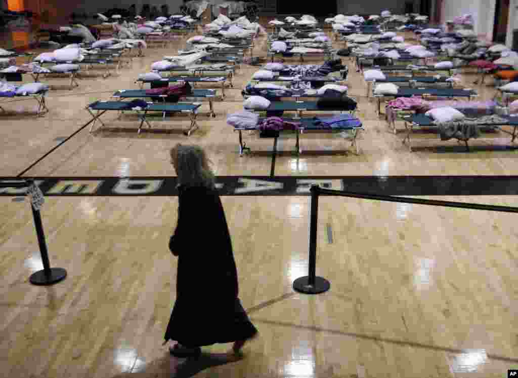 A person walks through a makeshift shelter in a gymnasium at Toms River East High School as they arrive to vote Tuesday, Nov. 6, 2012, in Toms River, N.J. N.J. Voter turnout was heavy in several storm-ravaged Jersey Shore towns, with many voters expressi