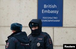 Russian policemen walk outside the British embassy in Moscow, Russia, March 17, 2018.