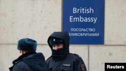 Des policiers russes marchent devant l'ambassade britannique à Moscou, en Russie, le 17 mars 2018.