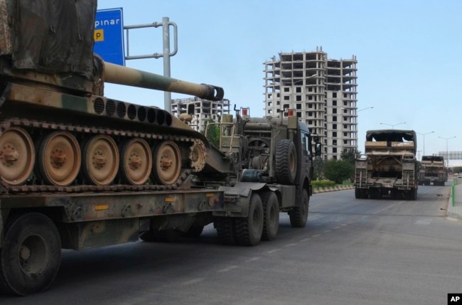 FILE - A convoy of Turkish military trucks carrying tanks destined for Syria, moves near the town of Kilis, Turkey,Sept. 14, 2018.
