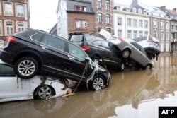 A picture taken on July 15, 2021 shows cars piled up by the water at a roundabout in the Belgian city of Verviers, after heavy rains and floods lashed western Europe, killing at least two people in Belgium. (Photo by François WALSCHAERTS / AFP)