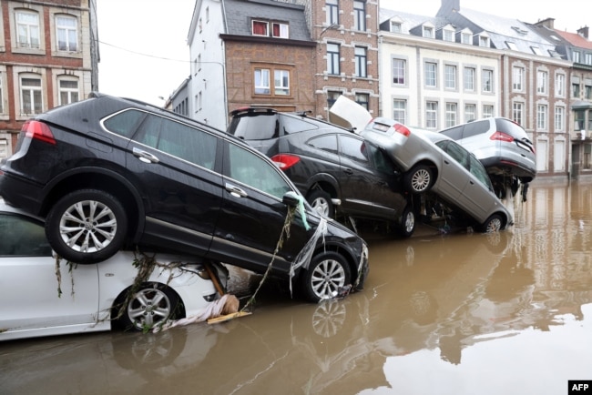 A picture taken on July 15, 2021 shows cars piled up by the water at a roundabout in the Belgian city of Verviers, after heavy rains and floods lashed western Europe, killing at least two people in Belgium. (Photo by François WALSCHAERTS / AFP)