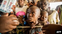 FILE - Congolese refugees look on during the distribution of biscuits in Sebagoro, Uganda, on Feb. 15, 2018.