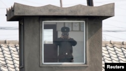지난 4월 북한 접경도시 신의주의 국경 초소에서 북한 병사가 망원경으로 중국 쪽을 바라보고 있다. 압록강 너머 중국 단둥에서 촬영한 사진이다.