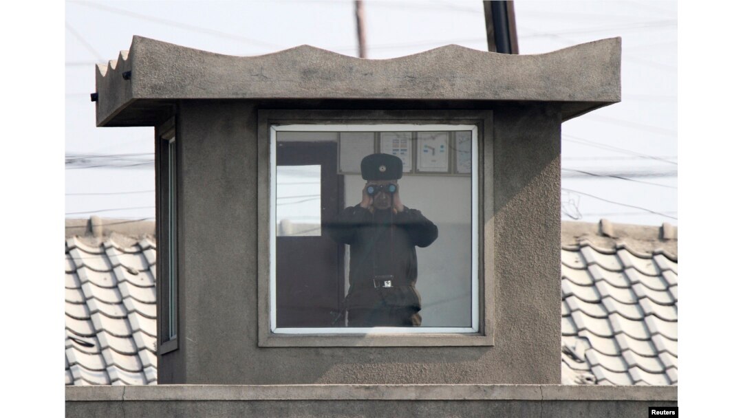 북한 접경도시 신의주의 국경 초소에서 북한 병사가 망원경으로 중국 쪽을 바라보고 있다. (자료사진)