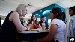 FILE - Democratic presidential candidate Sen. Kirsten Gillibrand (L) speaks with Alexa Arredondo, 9, while meeting with community activists on immigration issues at a restaurant, May 6, 2019, in Las Vegas. 