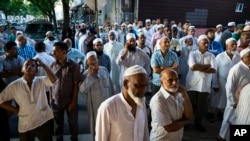 FILE - People gather near a crime scene for a demonstration after the leader of a New York City mosque and an associate were fatally shot in a brazen daylight attack as they left afternoon prayers Saturday. 