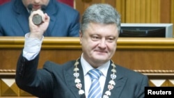 Ukraine's President-elect Petro Poroshenko shows the presidential seal during his inauguration ceremony in the parliament hall in Kyiv, June 7, 2014.