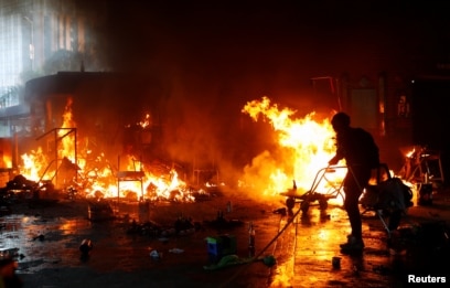 A protester attempts to extinguish a fire at the campus of Hong Kong Polytechnic University (PolyU) during clashes with police in Hong Kong, China, November 18, 2019.