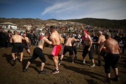 Pria Muslim Bulgaria memperagakan gulat minyak saat ritual menjelang upacara sunat massal di Desa Ribnovo, Bulgaria, 23 Februari 2020. (Foto: REUTERS/Stoyan Nenov)