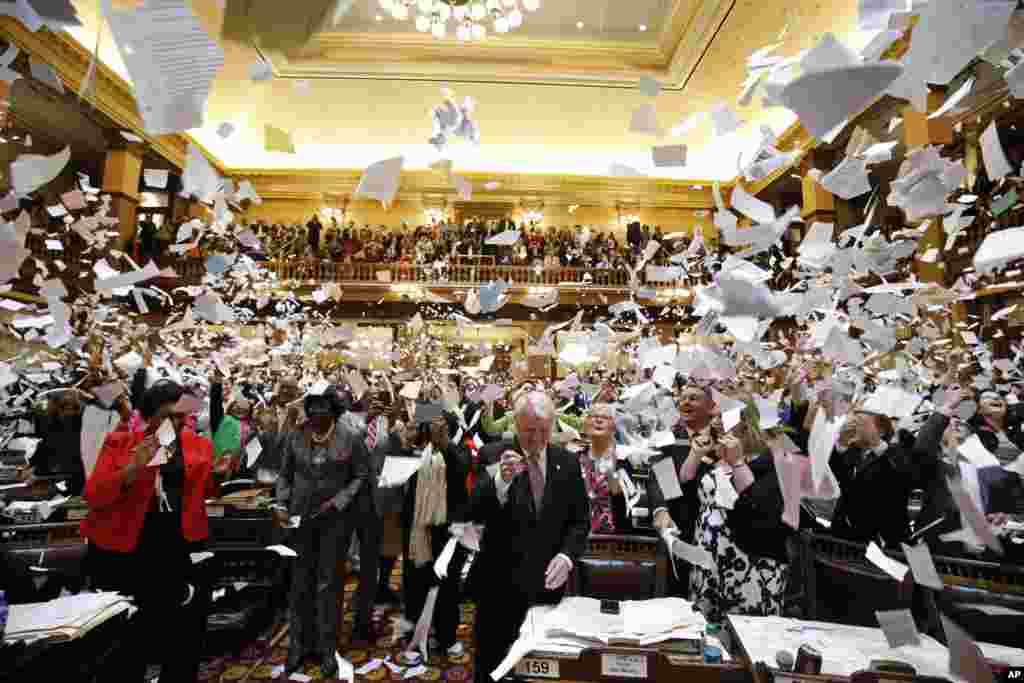 Representatives throw papers up in the air at the conclusion of the final day of the Georgia General Assembly at the capitol in Atlanta.
