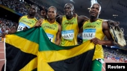 FILE: Men's 4x100m relay Asafa Powell, Usain Bolt, Michael Frater, Nesta Carter of Jamaica celebrate after winning the final of the athletics competition in the National Stadium during the Beijing 2008 Olympic Games, Aug. 22, 2008. 