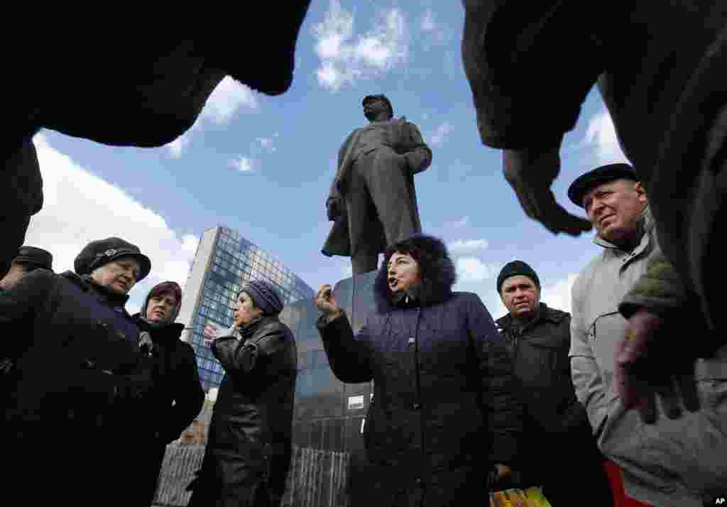 Warga membahas perkembangan Ukraina di pusat kota tempat patung pemimpin revolusi Soviet, Vladimir Lenin, berada di Donets, Ukraina (12/3). (AP/Sergei Grits)