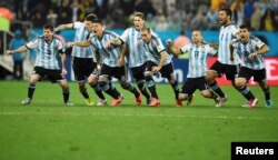 FILE - Argentina's national soccer players celebrate after their teammate Maxi Rodriguez scored the decisive goal during a shootout against the Netherlands at their 2014 World Cup semi-finals in Sao Paulo, July 9, 2014.