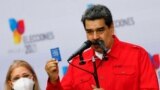 El presidente de Venezuela, Nicolás Maduro, sostiene una pequeña Constitución venezolana junto a su esposa Cilia Flores en Caracas, Venezuela, el 21 de noviembre del 2021. 