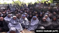 博科圣地公布的录像显示5月12日被他们绑架的女学生身着黑色和灰色长袍在一个乡村地区祈祷