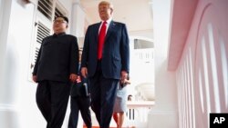North Korea leader Kim Jong Un and U.S. President Donald Trump walk along the balconies at the Capella resort on Sentosa Island, June 12, 2018 in Singapore.