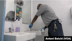 Un operario limpia los baños públicos del programa "Pit Stop" para que las personas sin hogar puedan asearse y mantener la higiene.