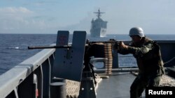 FILE - The Philippine Navy is upgrading its fleet amid growing maritime disputes. Here, one of its troops fires a .50-caliber machine gun during a bilateral maritime exercise between the Philippine Navy and U.S. Navy in the South China Sea.