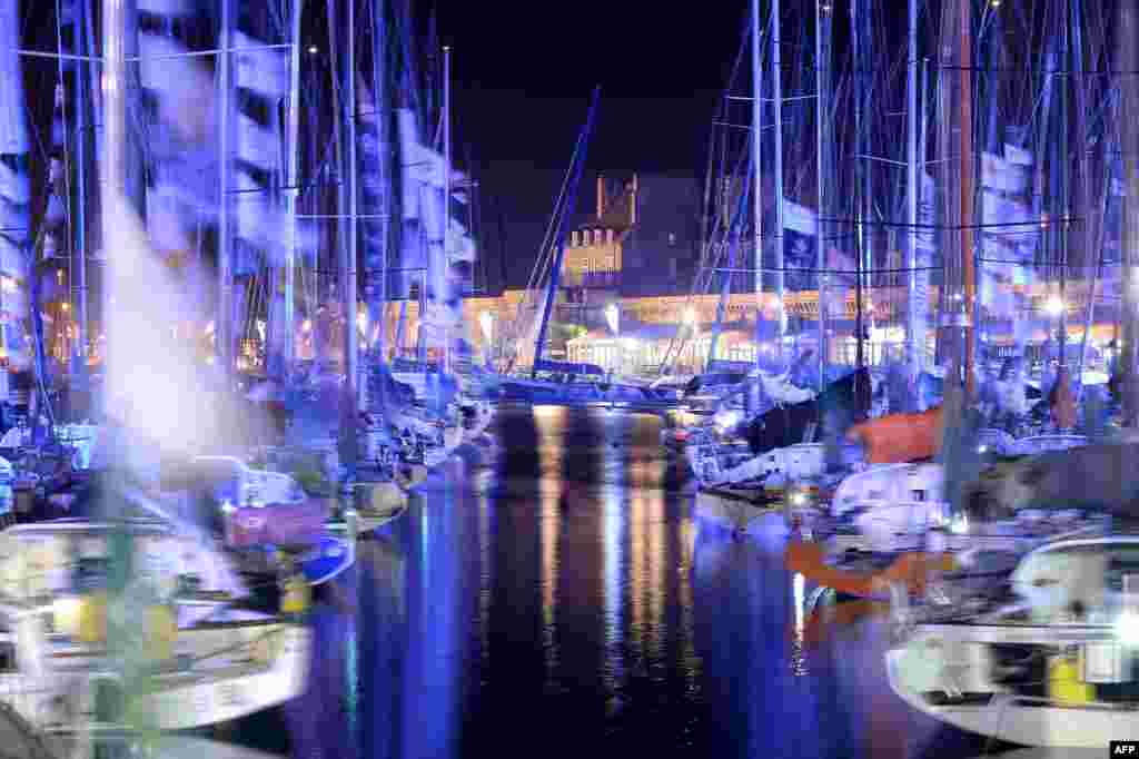 Picture taken on Oct. 29, 2014 with low speed exposure shows the class 40 monohulls by night in Saint Malo, western France, before the 10th edition of the Route du Rhum sailing race to start on Nov. 2, 2014. 