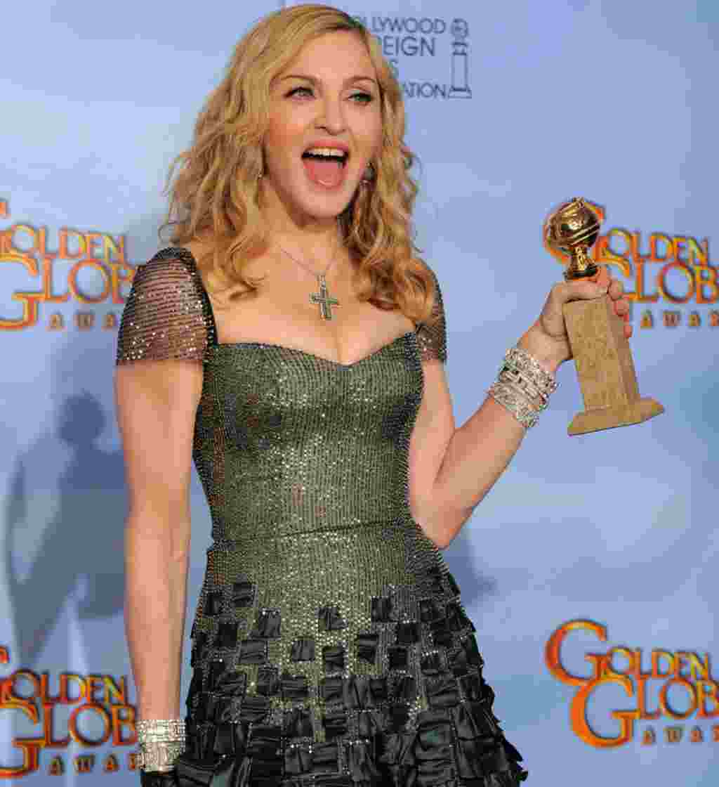 Madonna berpose di balik panggung dengan penghargaan Lagu Asli Terbaik untuk Film dengan lagunya, "Masterpiece" dari film "W.E." (AP).