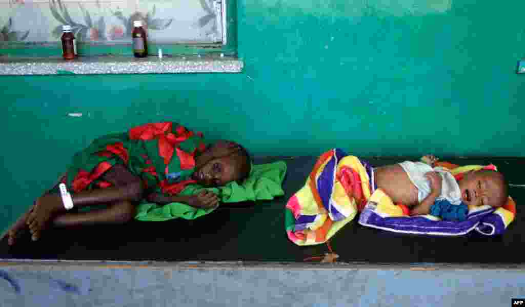 July 12: Two severely malnourished children from Somalia lie on a table in Banadir hospital, Mogadishu, Somalia. (AP Photo/Farah Abdi Warsameh)