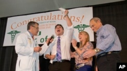 FILE - Medical student Matthew Stark, center, celebrates with his parents and Pascal J. Goldschmidt, left, dean for the University of Miami Miller School of Medicine, after learning which residency training program he was matched with, March 18, 2016.